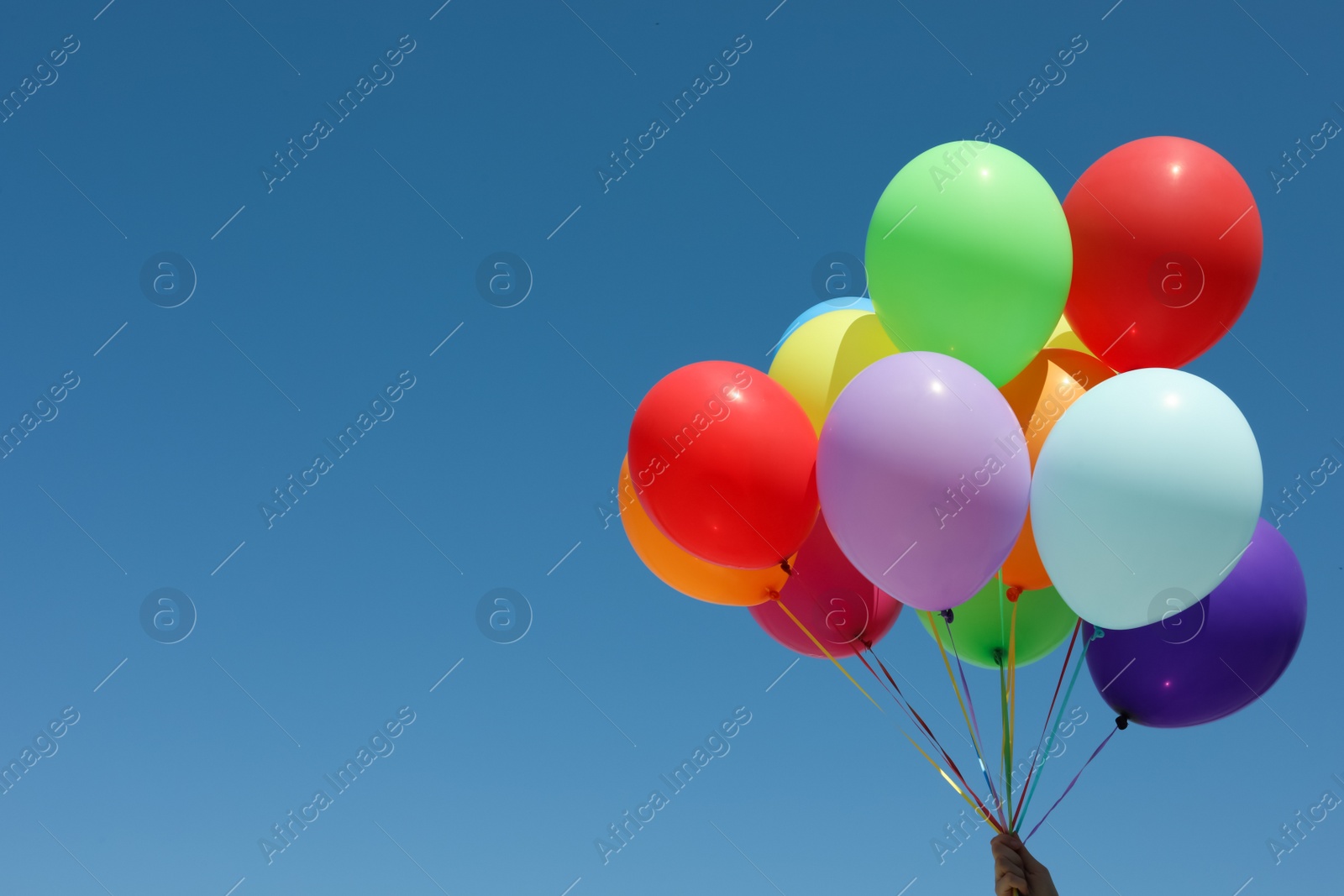Photo of Woman with bunch of colorful balloons against blue sky. Space for text