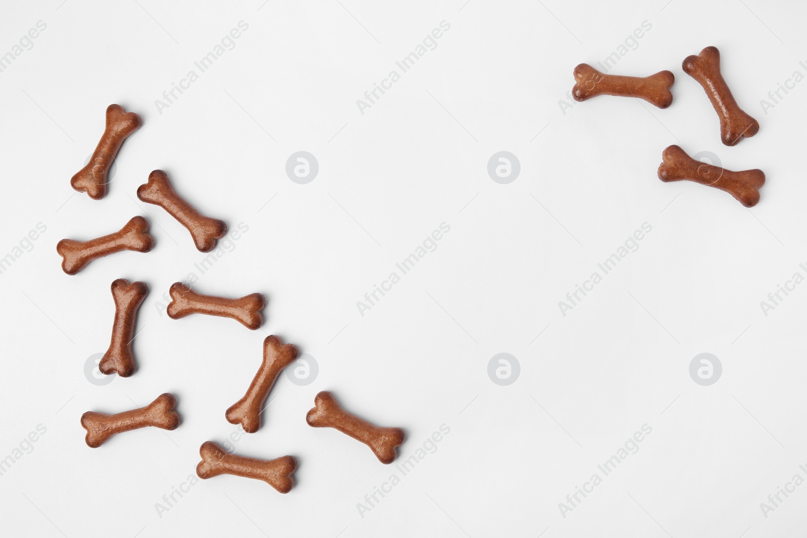Photo of Bone shaped dog cookies on white background, flat lay. Space for text