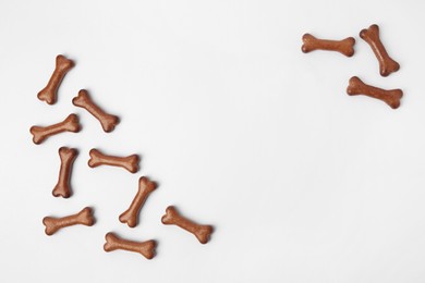 Bone shaped dog cookies on white background, flat lay. Space for text