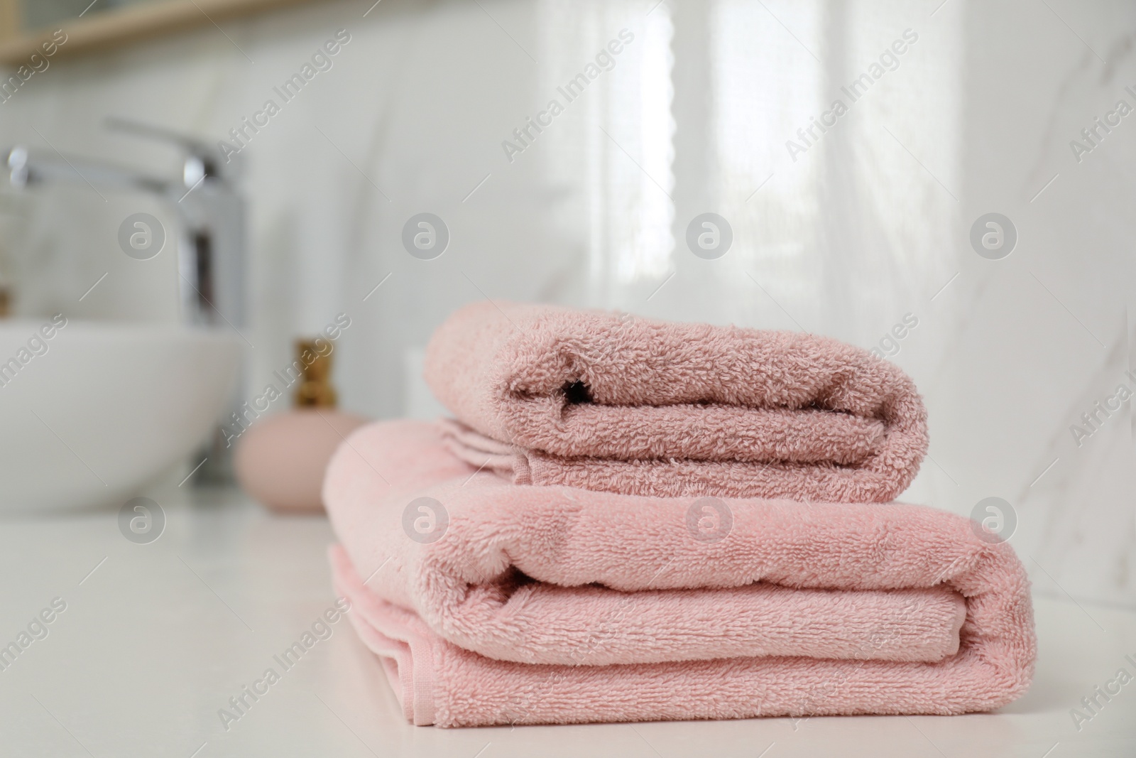 Photo of Stack of clean towels on bathroom countertop