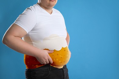 Beer belly problem. Overweight man on blue background, closeup