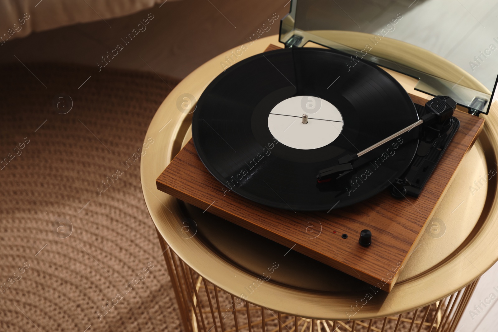Photo of Stylish turntable with vinyl disc in room, above view