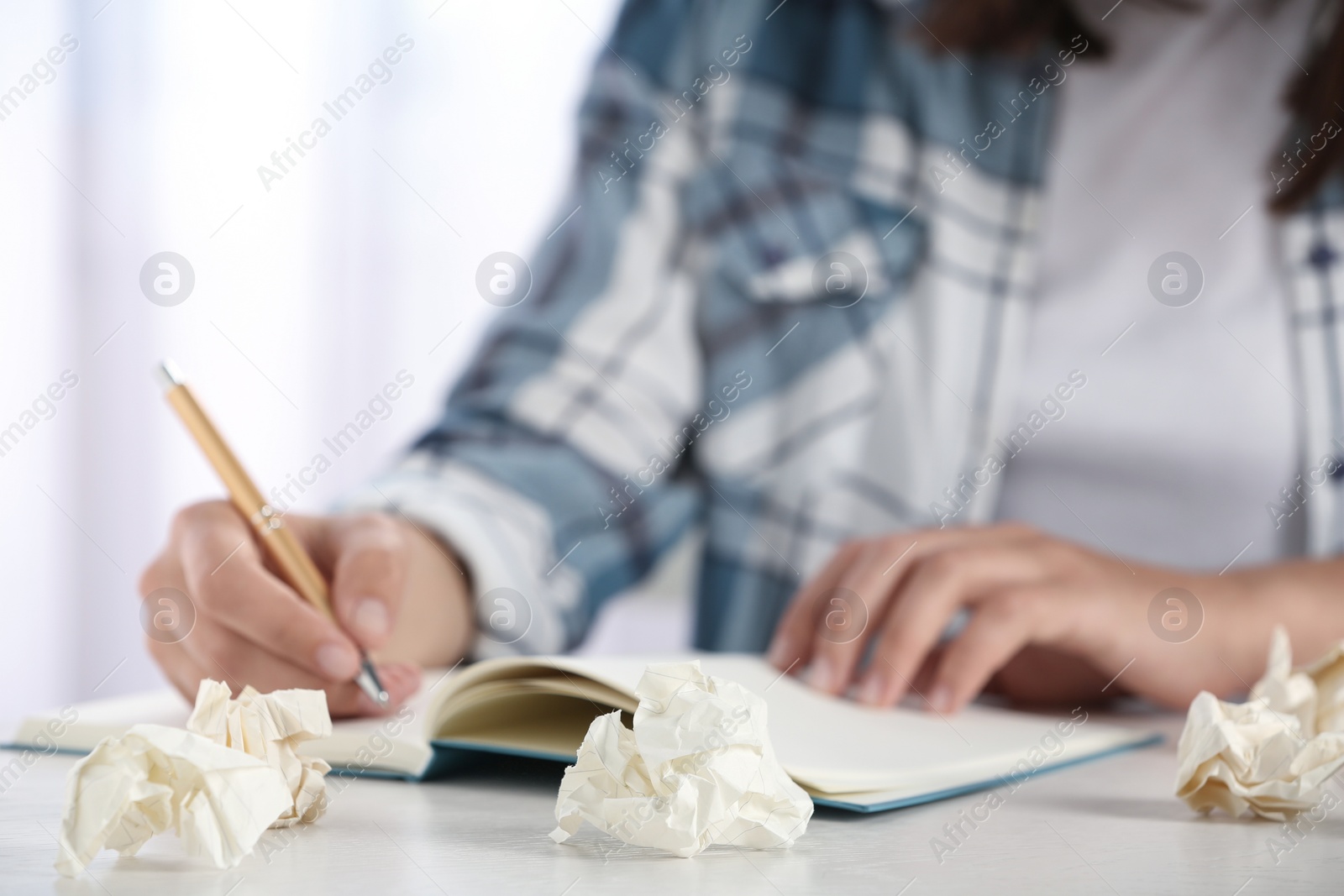 Photo of Woman working at table with crumpled paper, closeup. Generating idea