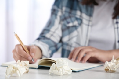 Photo of Woman working at table with crumpled paper, closeup. Generating idea