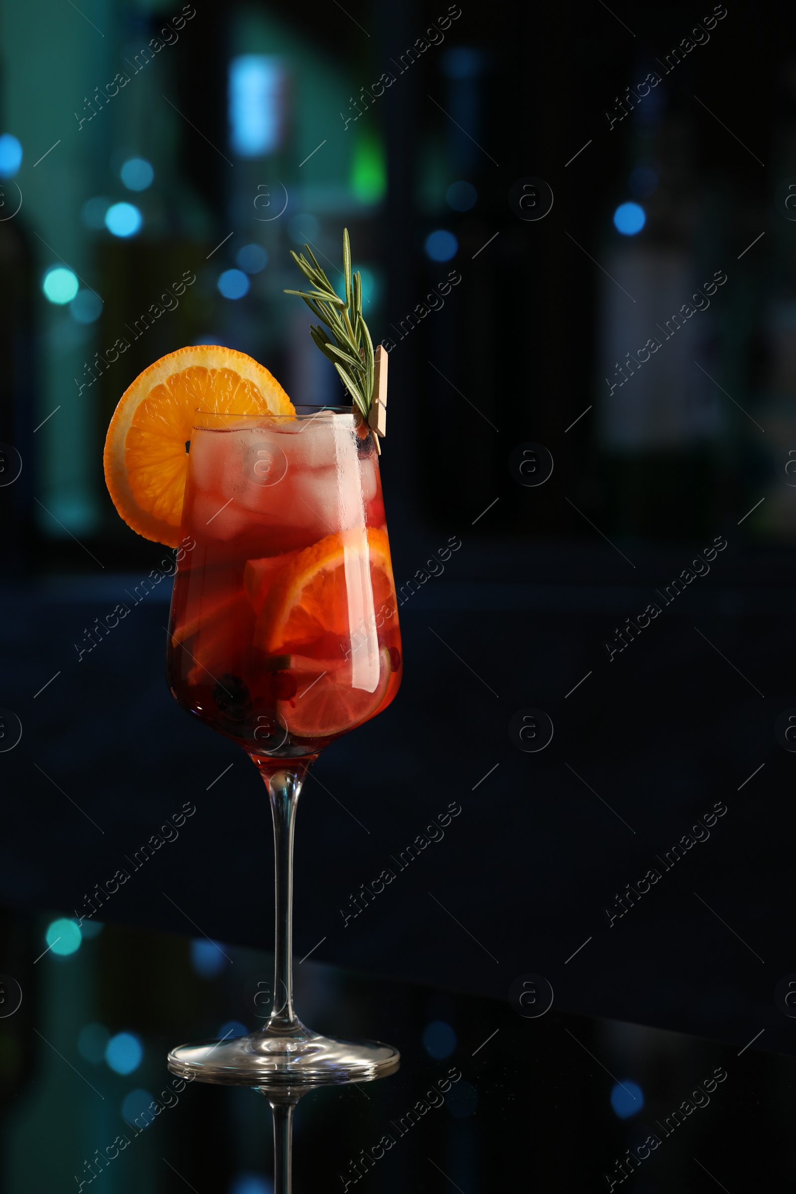 Photo of Delicious sangria cocktail on black table in bar