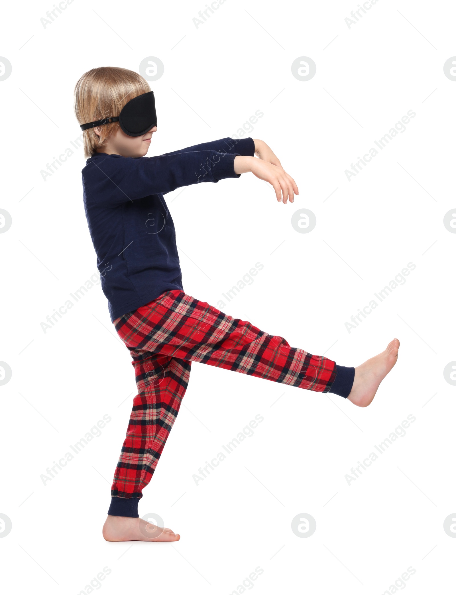Photo of Boy in pajamas and sleep mask sleepwalking on white background