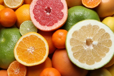 Photo of Different ripe citrus fruits as background, top view