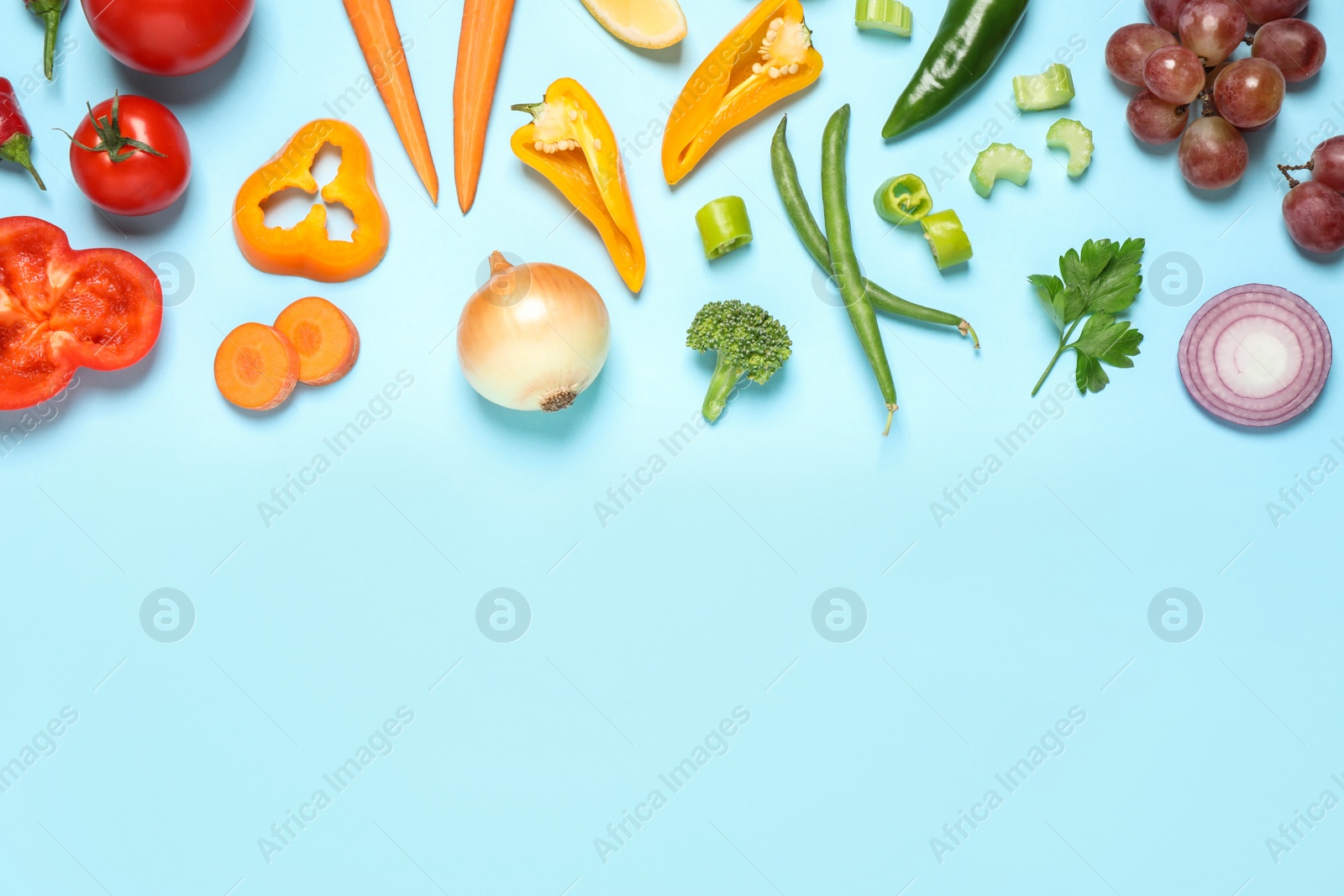 Photo of Fresh organic fruits and vegetables on light blue background, flat lay. Space for text