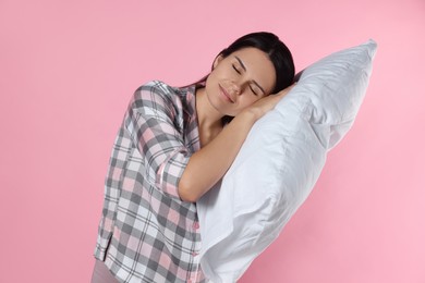 Photo of Sleepy young woman with soft pillow on pink background