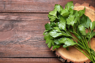 Photo of Bunch of fresh green parsley on wooden table, top view. Space for text