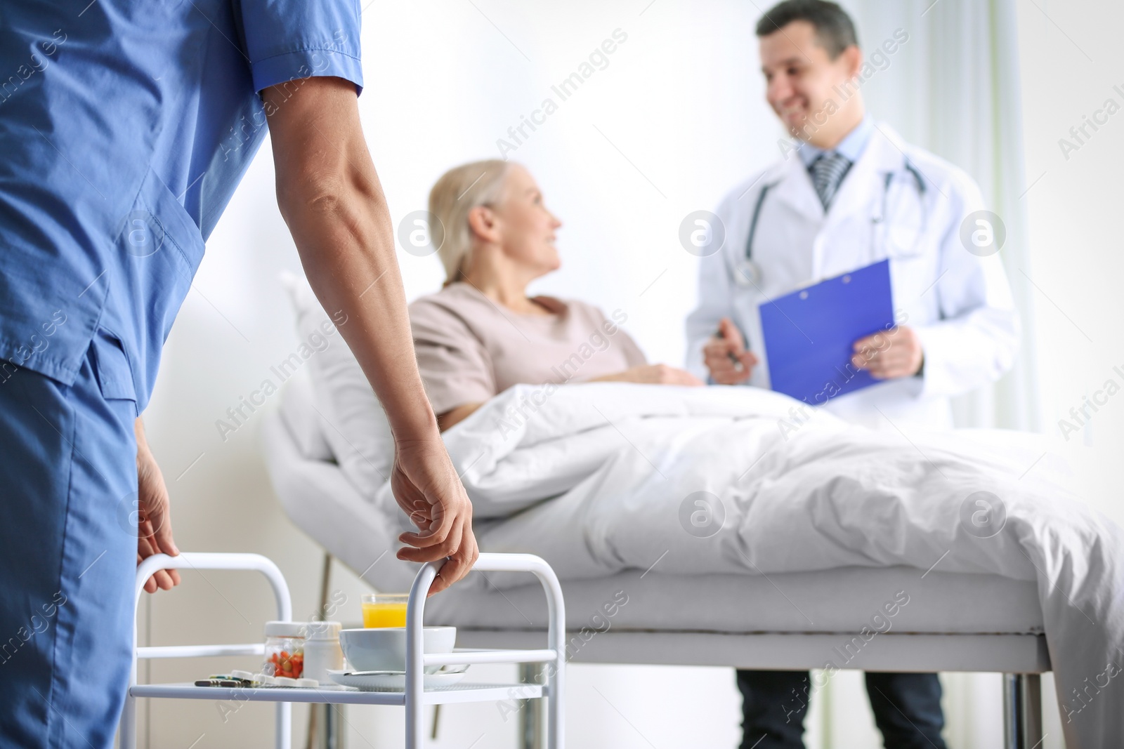 Photo of Nurse bringing medicine on serving trolley for patient in hospital ward, closeup. Doctor's prescription