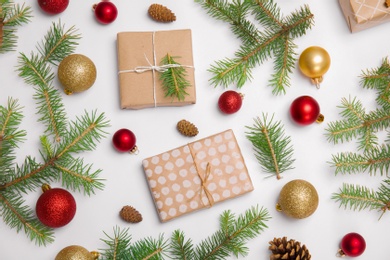 Composition with Christmas tree branches, festive decor and gift boxes on white background