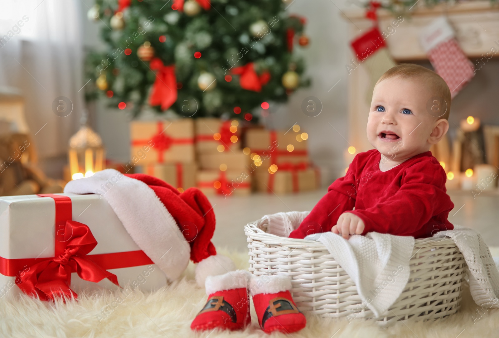 Photo of Cute baby sitting in basket at home. Christmas celebration