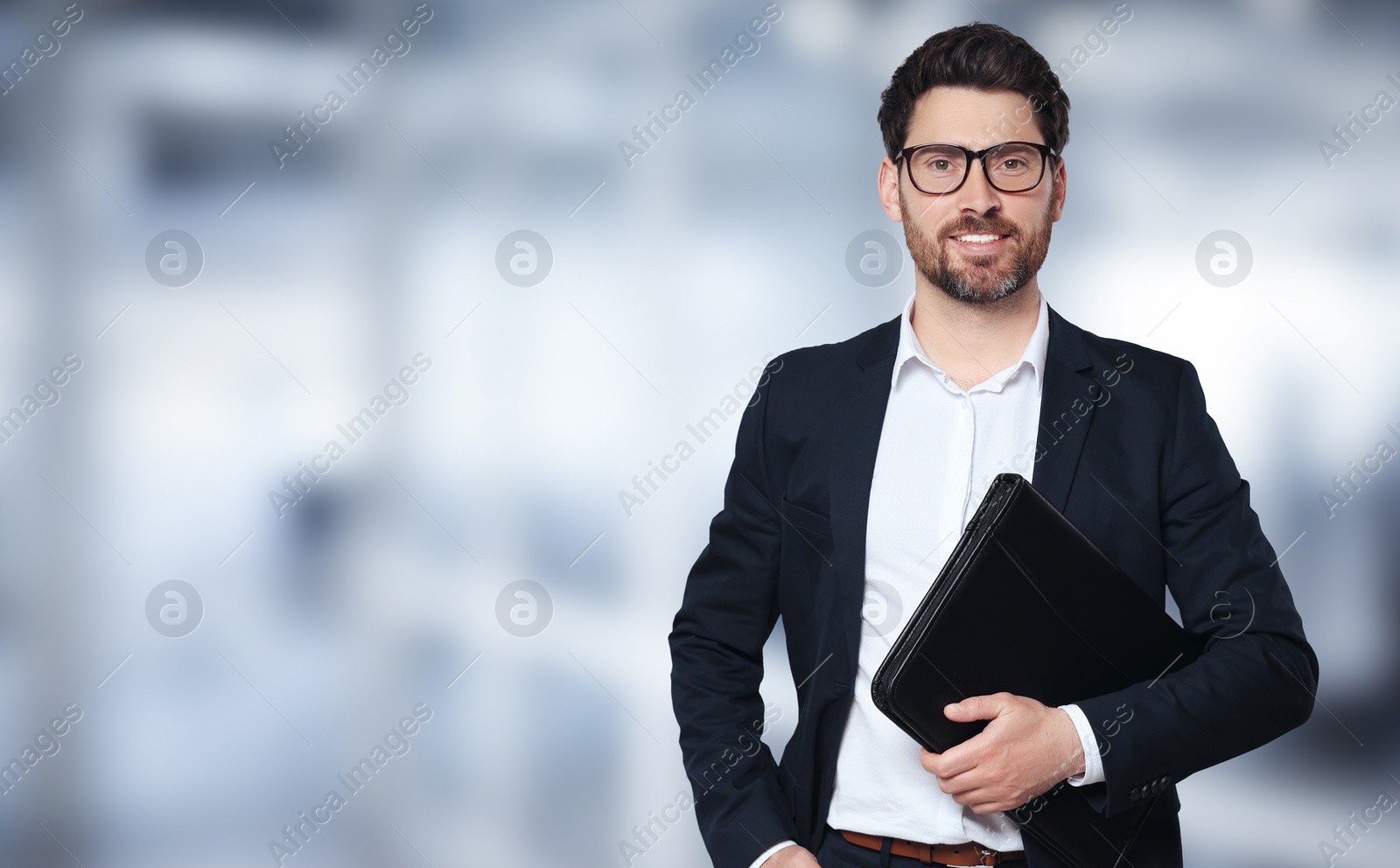 Image of Handsome real estate agent with leather portfolio in office, space for text