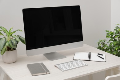 Photo of Cosy workspace with computer and stationery on desk at home