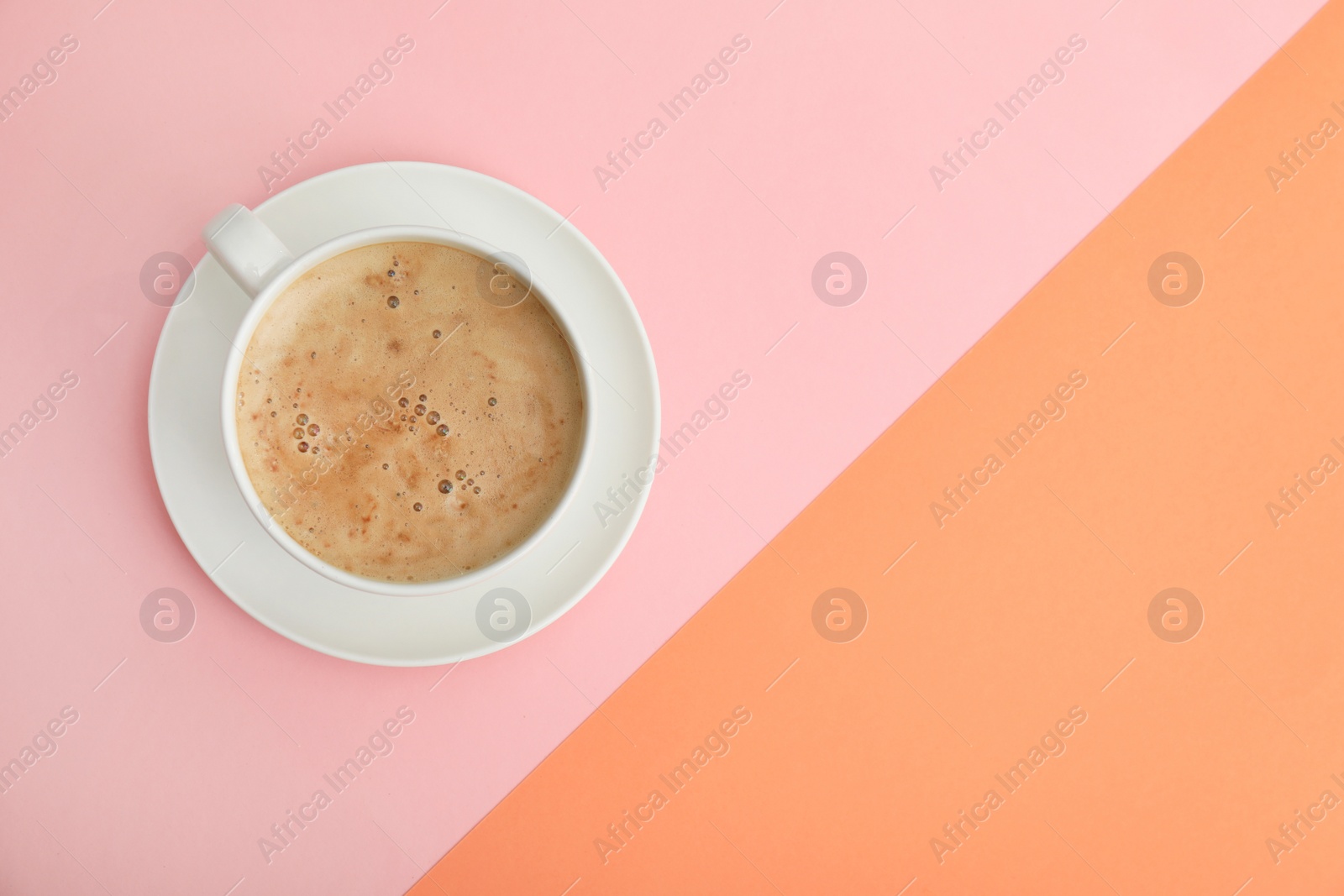 Photo of Cup of coffee on color background, top view. Space for text