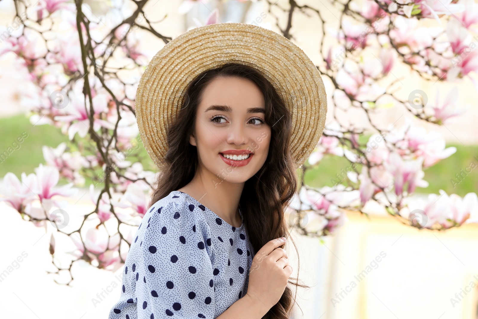 Photo of Beautiful woman near blossoming magnolia tree on spring day