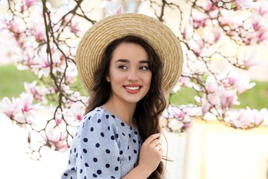 Photo of Beautiful woman near blossoming magnolia tree on spring day