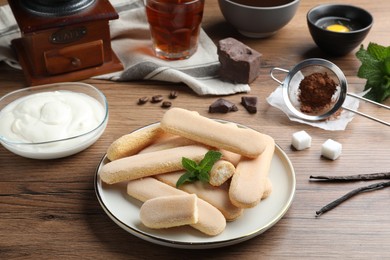 Tasty cookies and other ingredients for tiramisu on wooden table