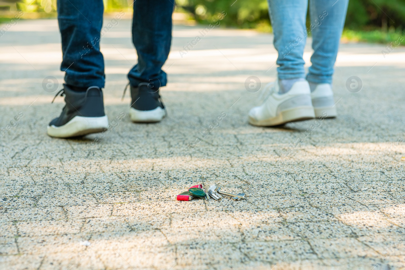 Photo of Men walking outside, focus on lost keys