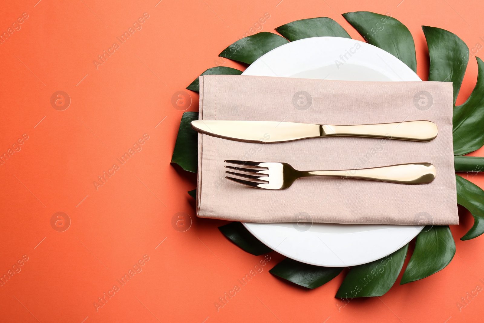 Photo of Elegant table setting on orange background, flat lay. Space for text