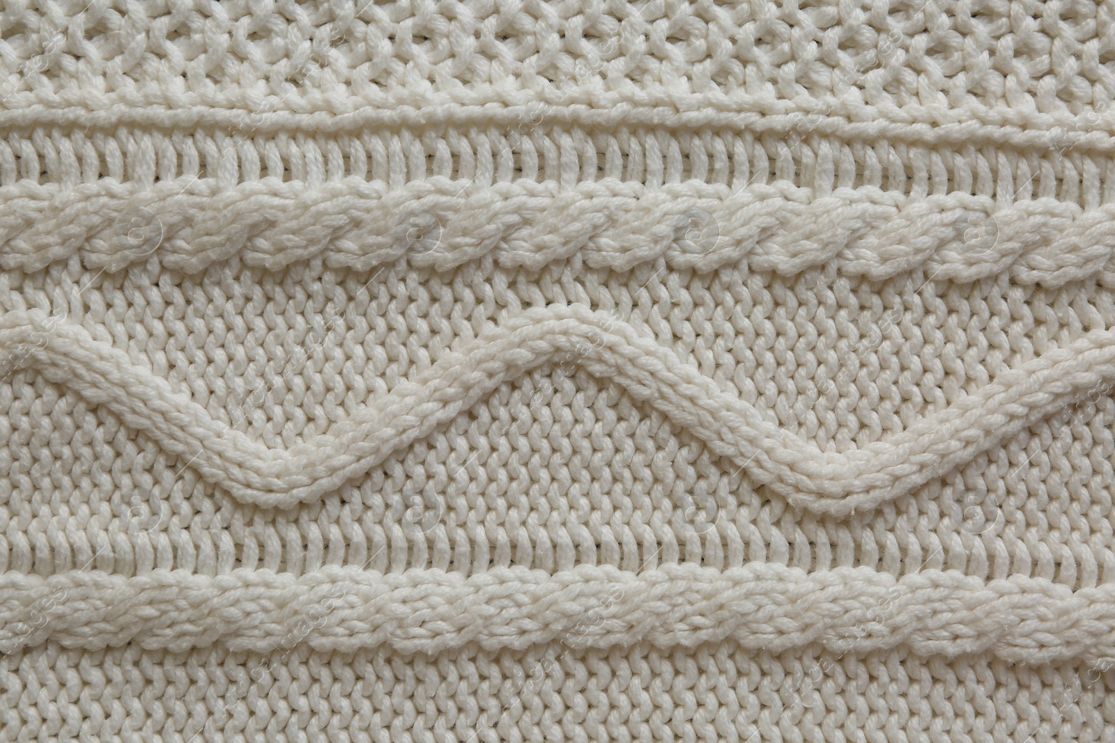 Photo of White knitted fabric with beautiful pattern as background, top view