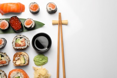Photo of Set of delicious sushi rolls on white background, flat lay. Space for text