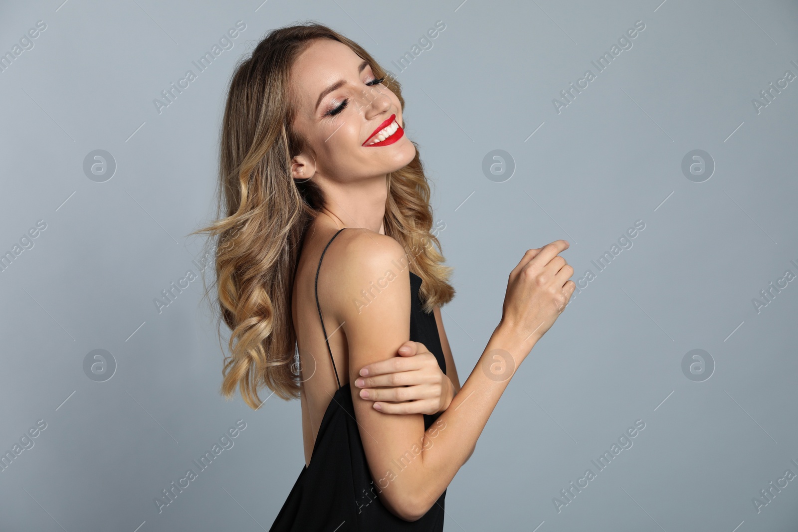 Photo of Happy young woman on grey background. Christmas celebration