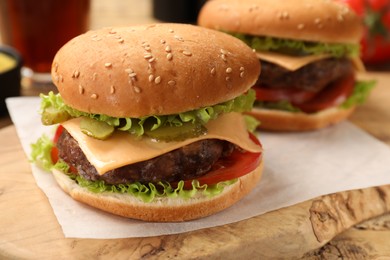Photo of Tasty hamburgers with patties on wooden table, closeup
