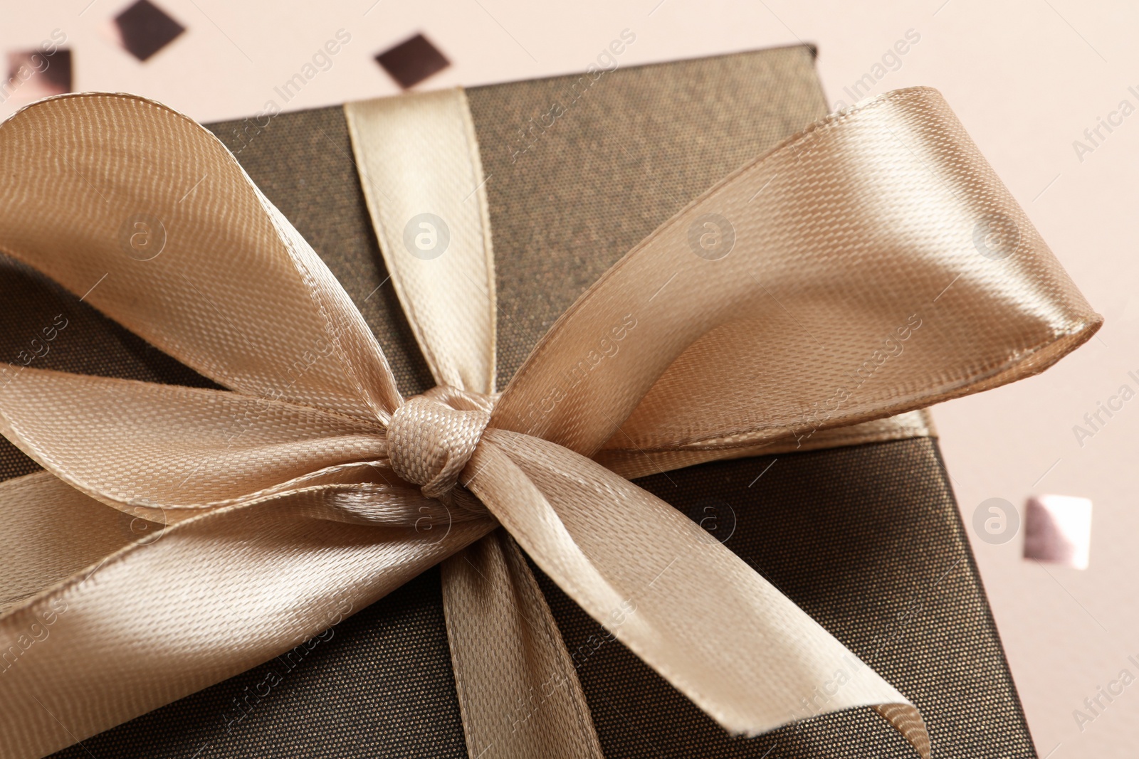Photo of Beautiful gift box with bow on beige background, closeup view