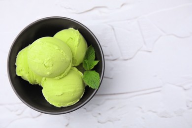 Photo of Tasty matcha ice cream in bowl on white textured table, top view. Space for text