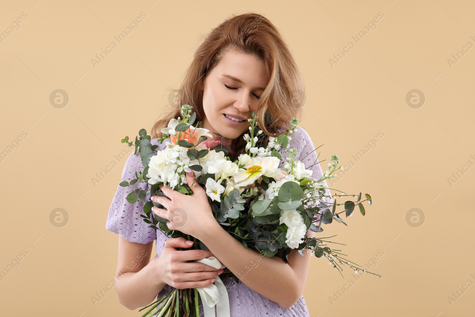 Photo of Beautiful woman with bouquet of flowers on beige background