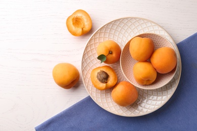 Composition with delicious apricots on white wooden background, top view. Space for text