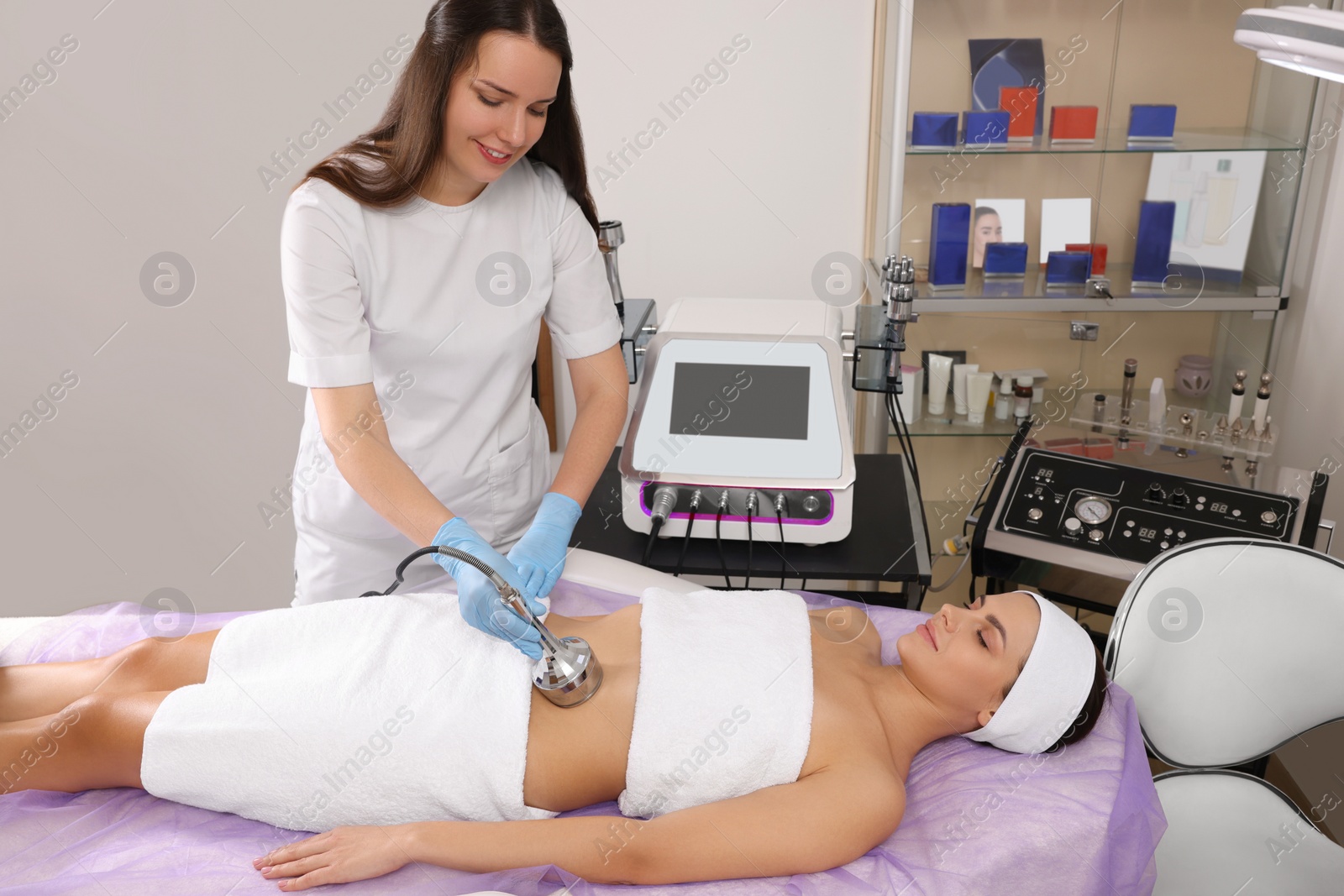 Photo of Young woman undergoing radio frequency lifting procedure in beauty salon