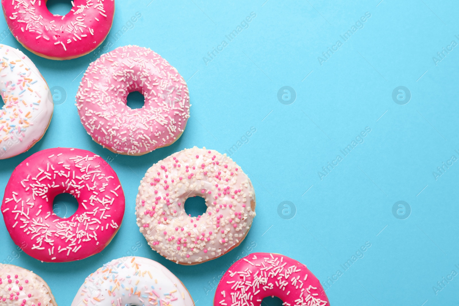 Photo of Delicious glazed doughnuts on color background, top view