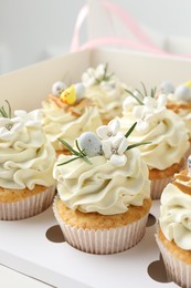 Tasty Easter cupcakes with vanilla cream in box, closeup