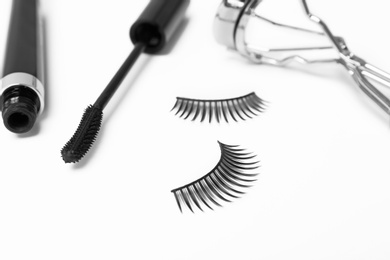 Photo of False eyelashes, mascara and curler on white background