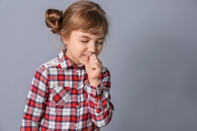 Photo of Little girl coughing on grey background