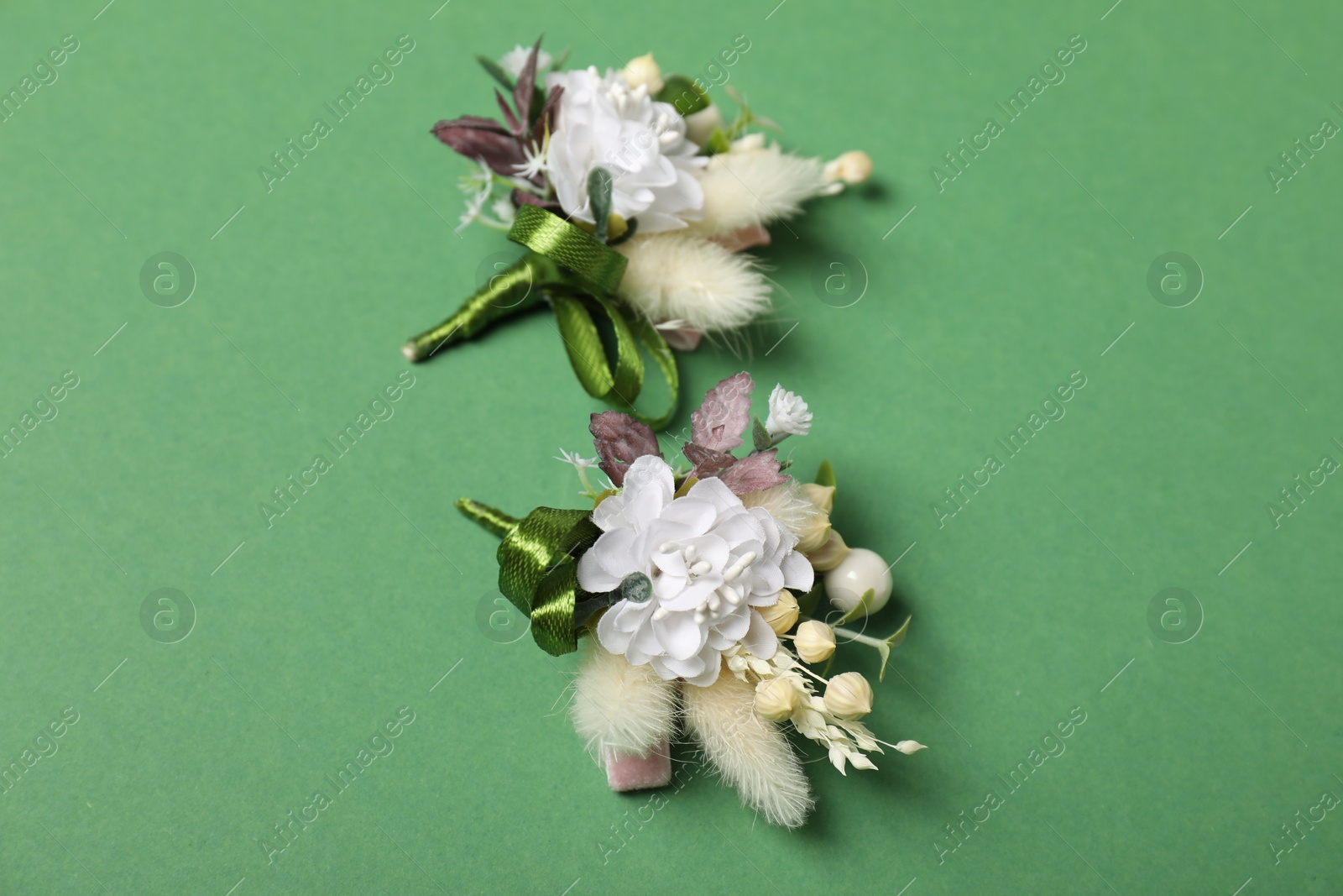 Photo of Stylish boutonniere on green background, above view