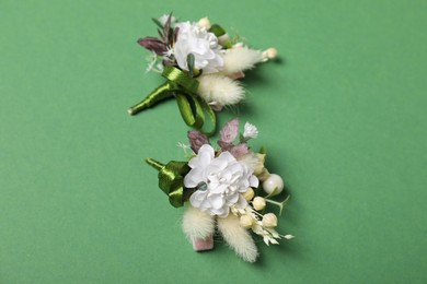 Photo of Stylish boutonniere on green background, above view