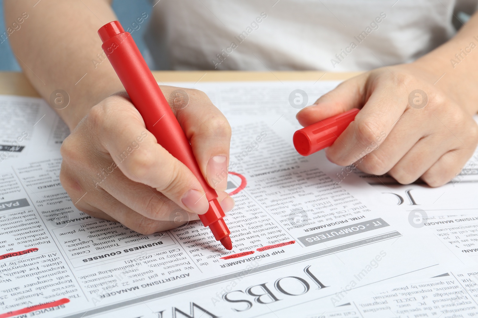 Photo of Woman marking advertisement in newspaper, closeup. Job search concept