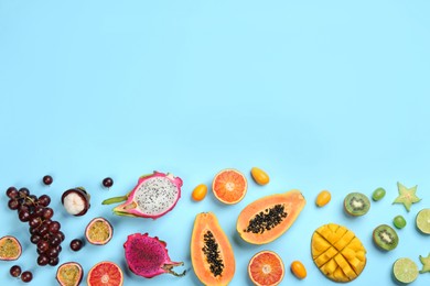 Many different delicious exotic fruits on light blue background, flat lay. Space for text