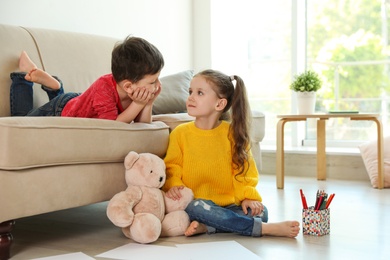 Photo of Cute little boy and girl in living room