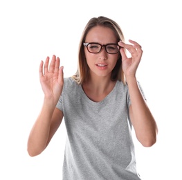 Young woman with vision problem wearing glasses on white background