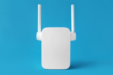 Photo of New modern Wi-Fi repeater on blue background