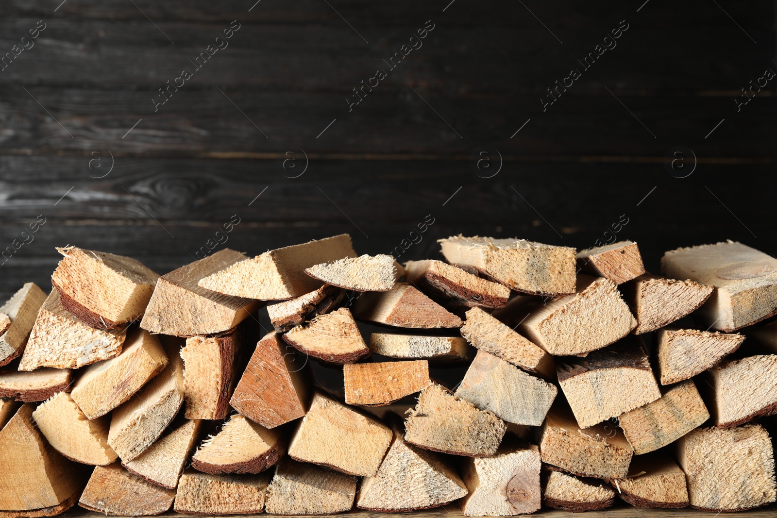 Photo of Cut firewood on black background. Heating in winter