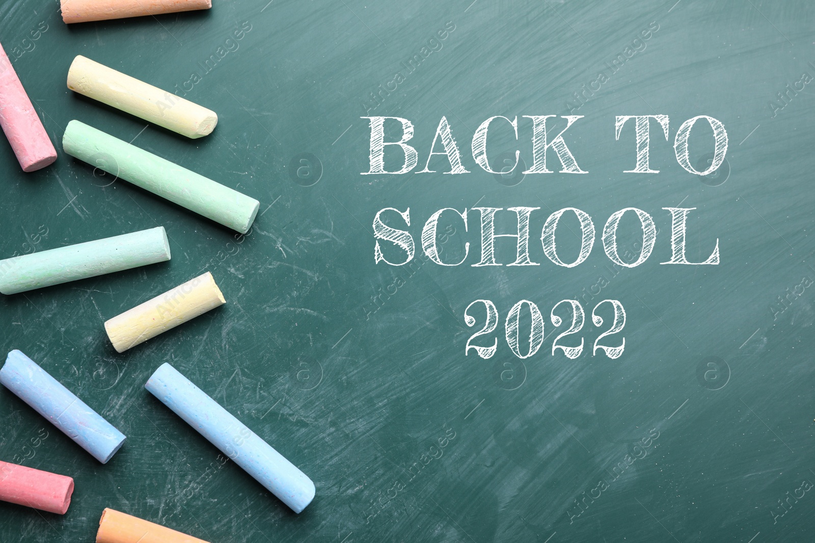 Image of Back to school 2022. Pieces of color chalk on greenboard, flat lay