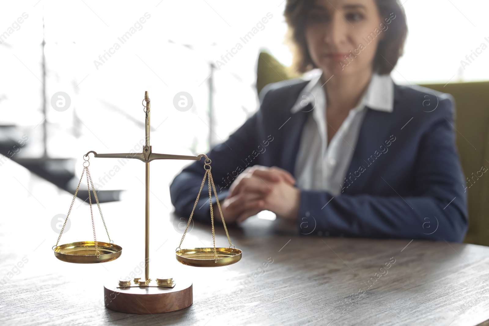 Photo of Scales on table and lawyer in office
