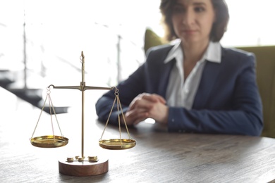 Scales on table and lawyer in office