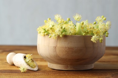 Fresh linden leaves and flowers on wooden table